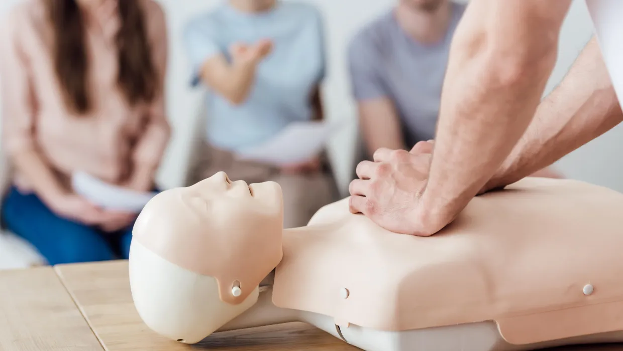 vista-recortada-instructor-que-realiza-compresion-toracica-maniqui-clase-entrenamiento-rcp-min